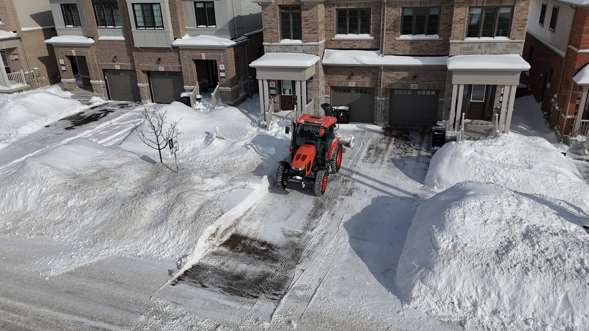 Aerial view of a Snowforce tractor clearing a residential driveway